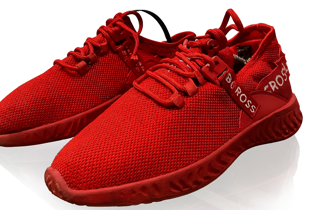 Red sneakers with a brand logo on a white background